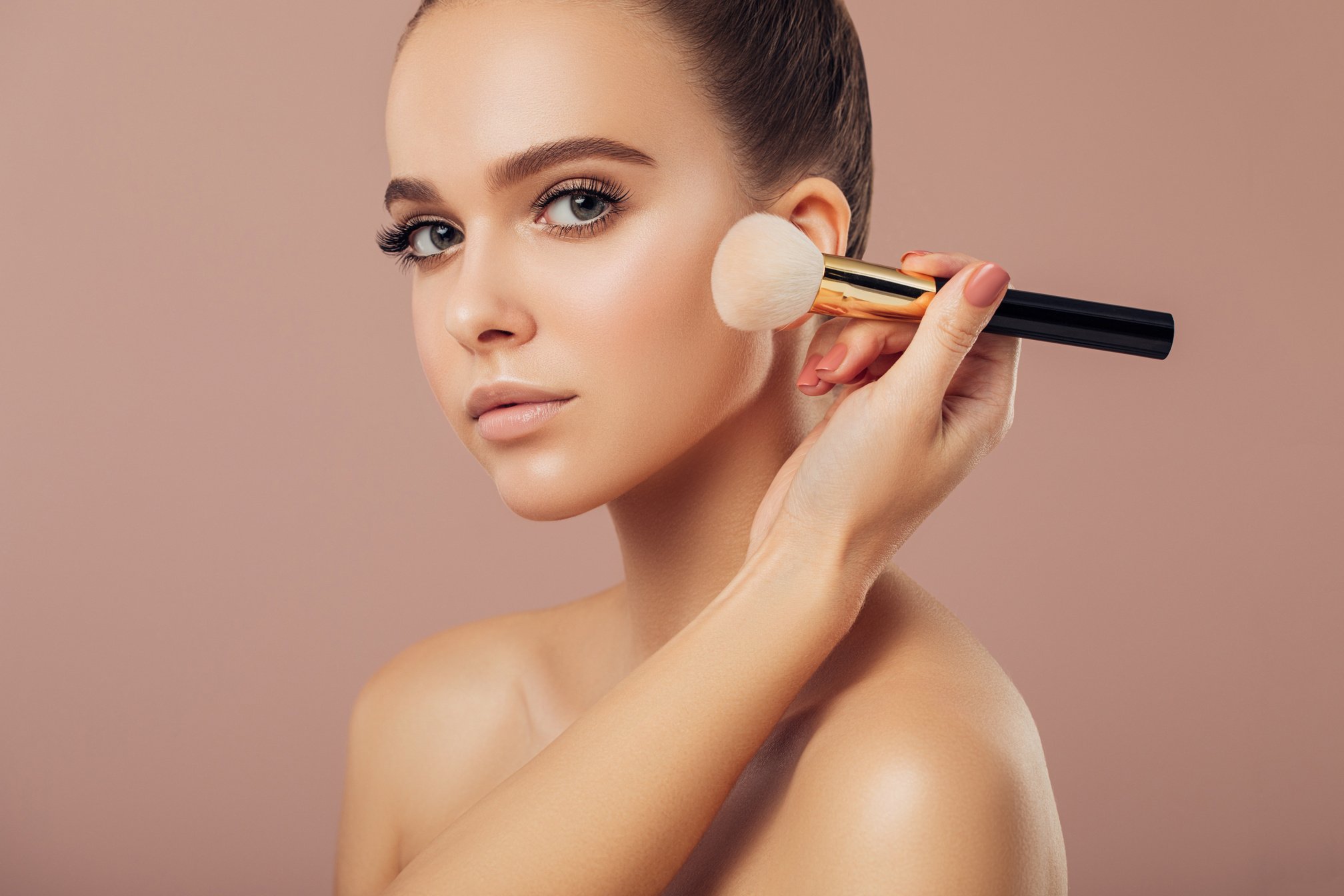 Young girl with perfect skin use makeup brush